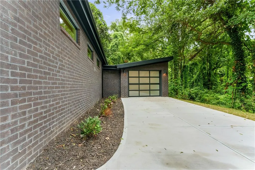 View of side of property with brick siding, driveway, and an attached garage