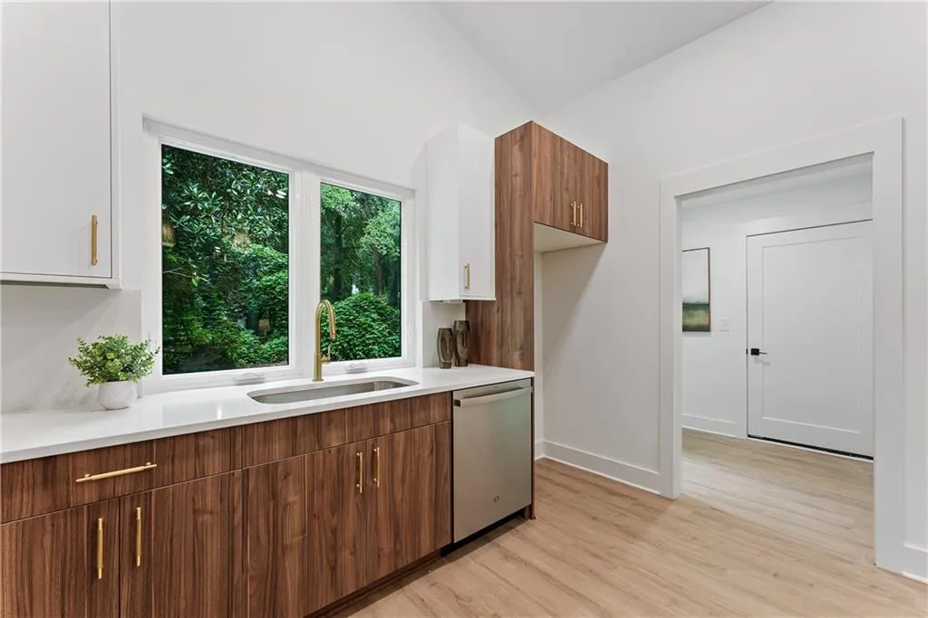 Kitchen with light countertops, light wood-style floors, dishwasher, white cabinetry, and modern cabinets