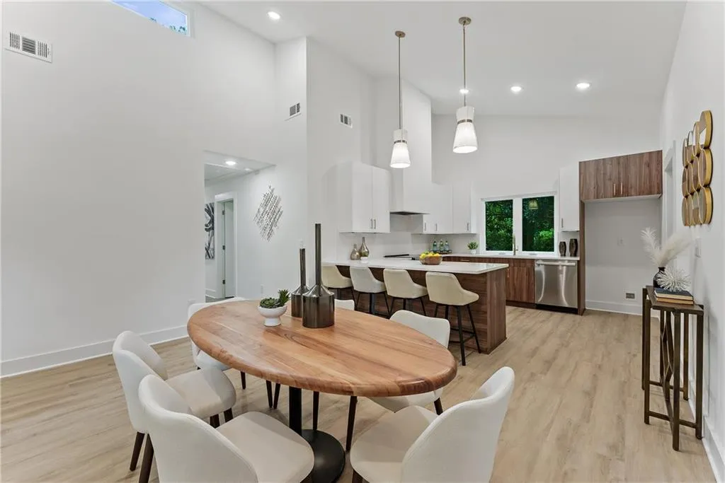Dining space featuring a high ceiling, light wood-type flooring, and recessed lighting
