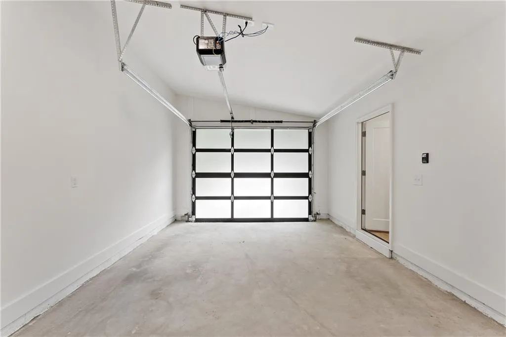 Garage with baseboards and a garage door opener