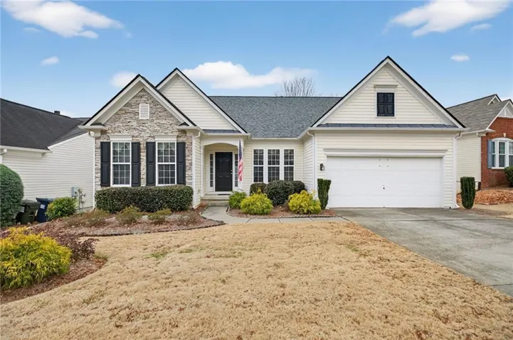 Cream siding exterior with stone accents and dark shutters