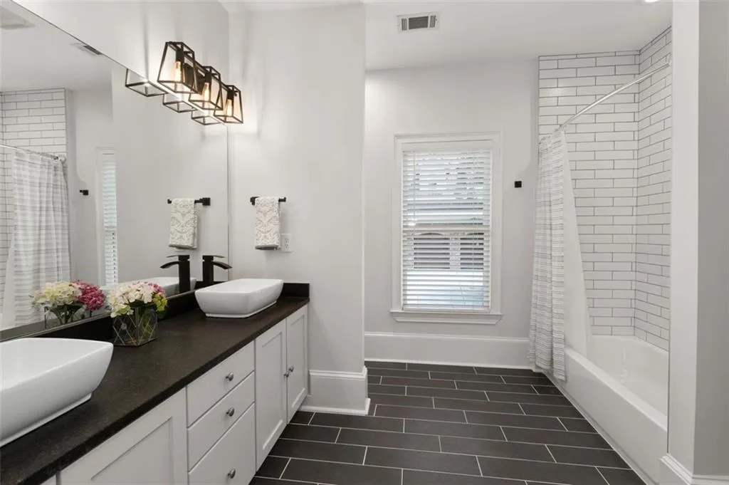 Large bathroom in the in-law suite has a double vanity & sleek tile shower