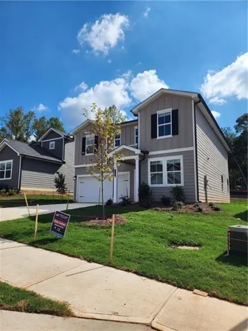 Two-story residential structure with gray siding, white trim, and black window shutters