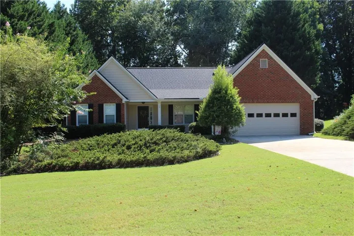 Red brick exterior with light siding accents, black shingle roof, and a two-car garage