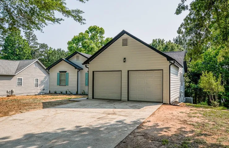 View of front of property with a garage, central AC, and concrete driveway