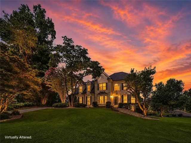Stately two-story residence with a dark-shingled roof and light-toned exterior