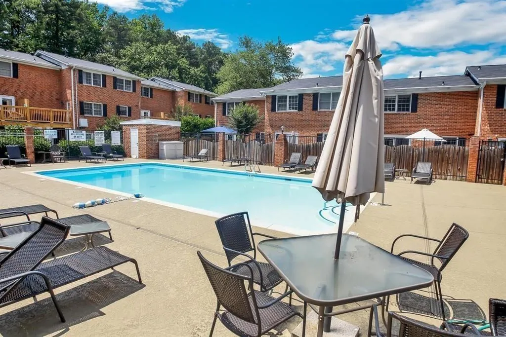 Community pool with a patio area and a residential view