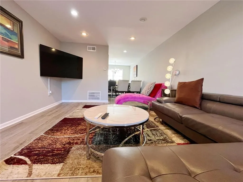 Living area featuring wood finished floors and suspended lighting