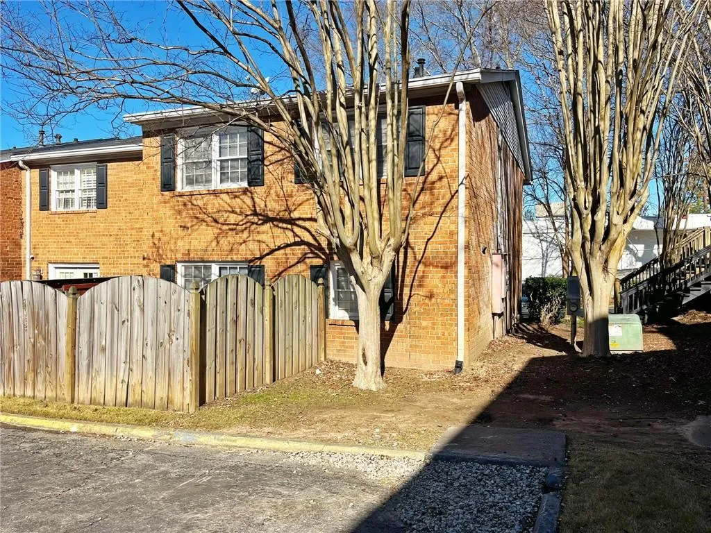 View of property exterior with brick siding and a gate
