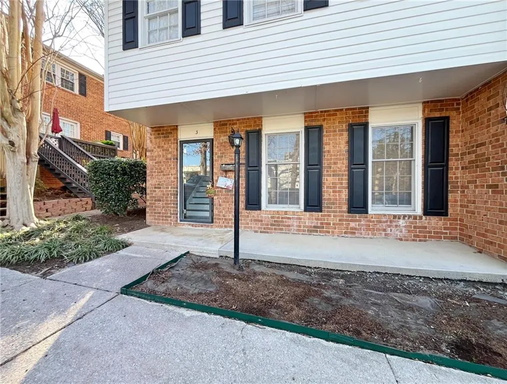 Entrance to property featuring brick siding and a porch