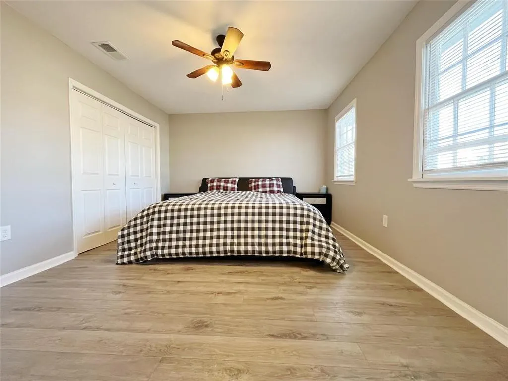 Bedroom featuring light wood-style flooring, ceiling fan, and a closet