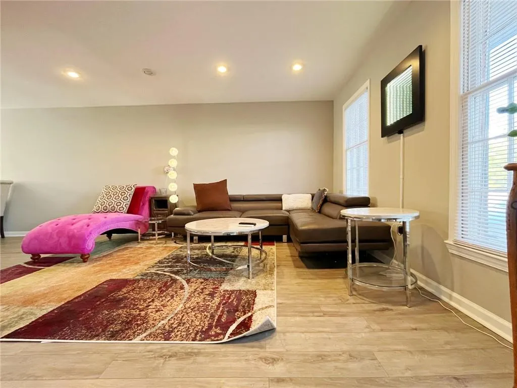 Living room with light wood-type flooring and recessed lighting