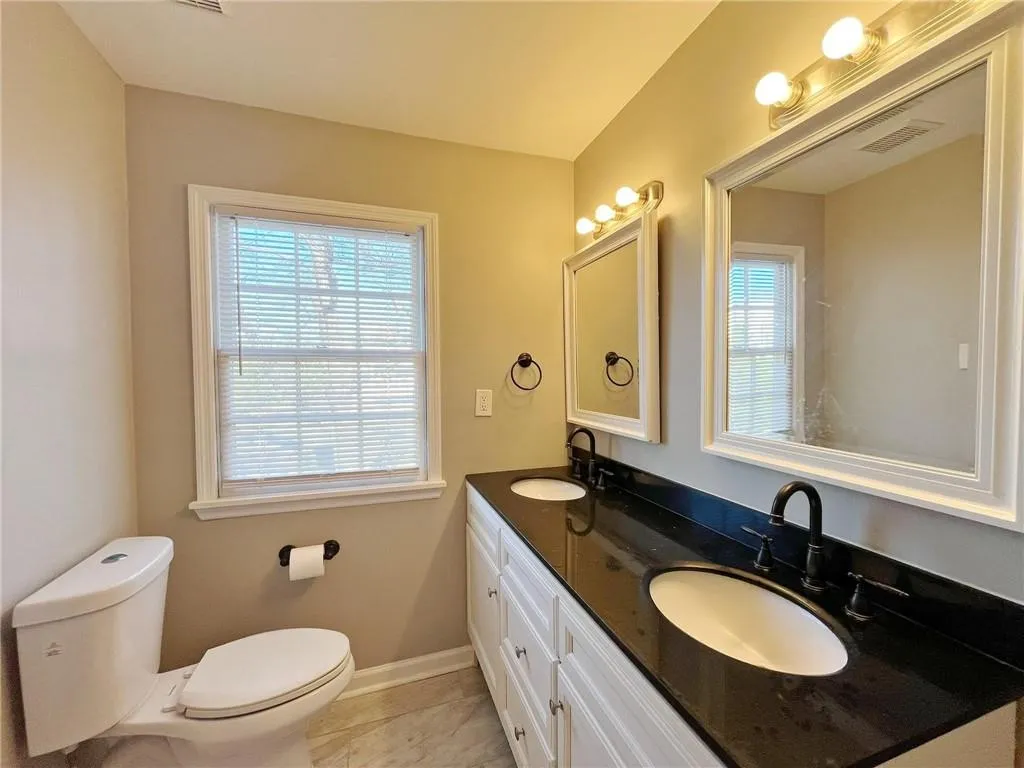 Full bath featuring double vanity and toilet