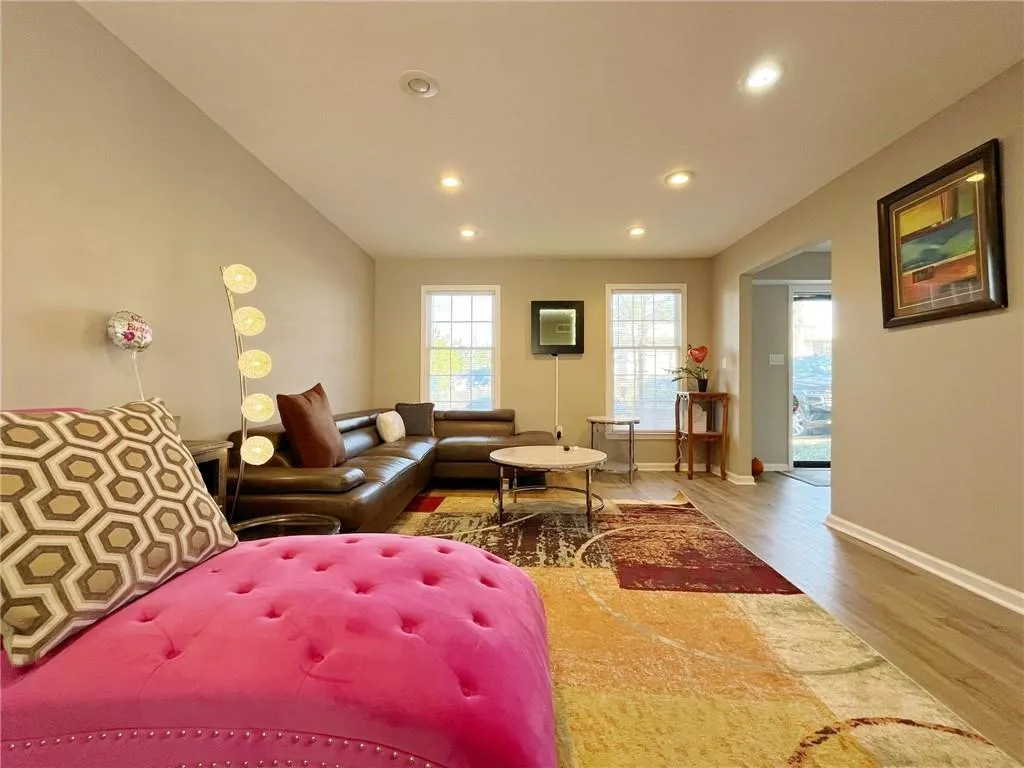 Living room with light wood-style flooring and recessed lighting