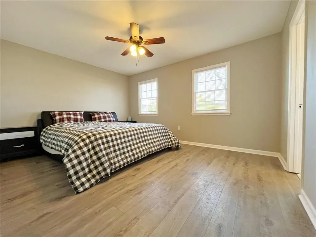 Bedroom with light wood-style flooring and a ceiling fan
