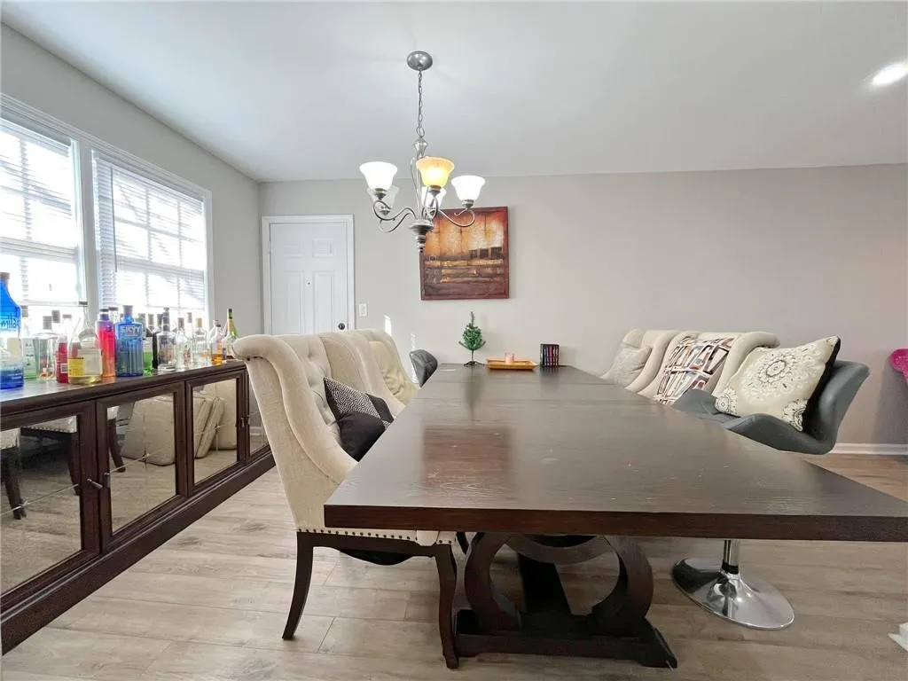 Dining space with hanging lights and light wood-style flooring