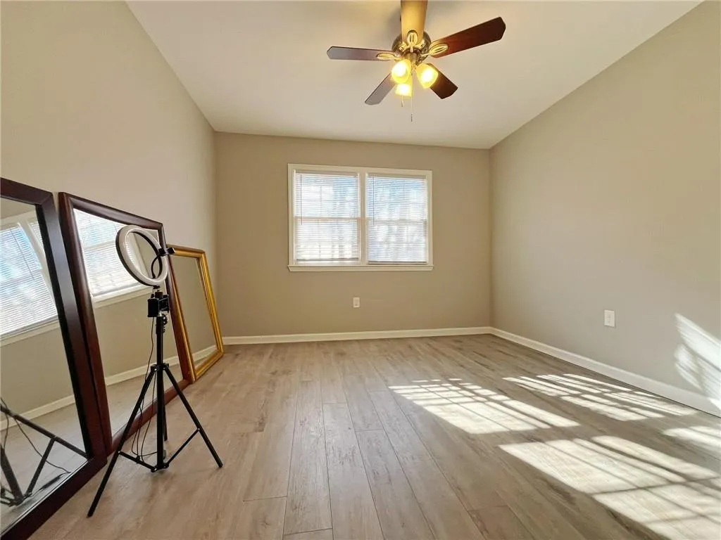 Unfurnished room with a ceiling fan and light wood-type flooring