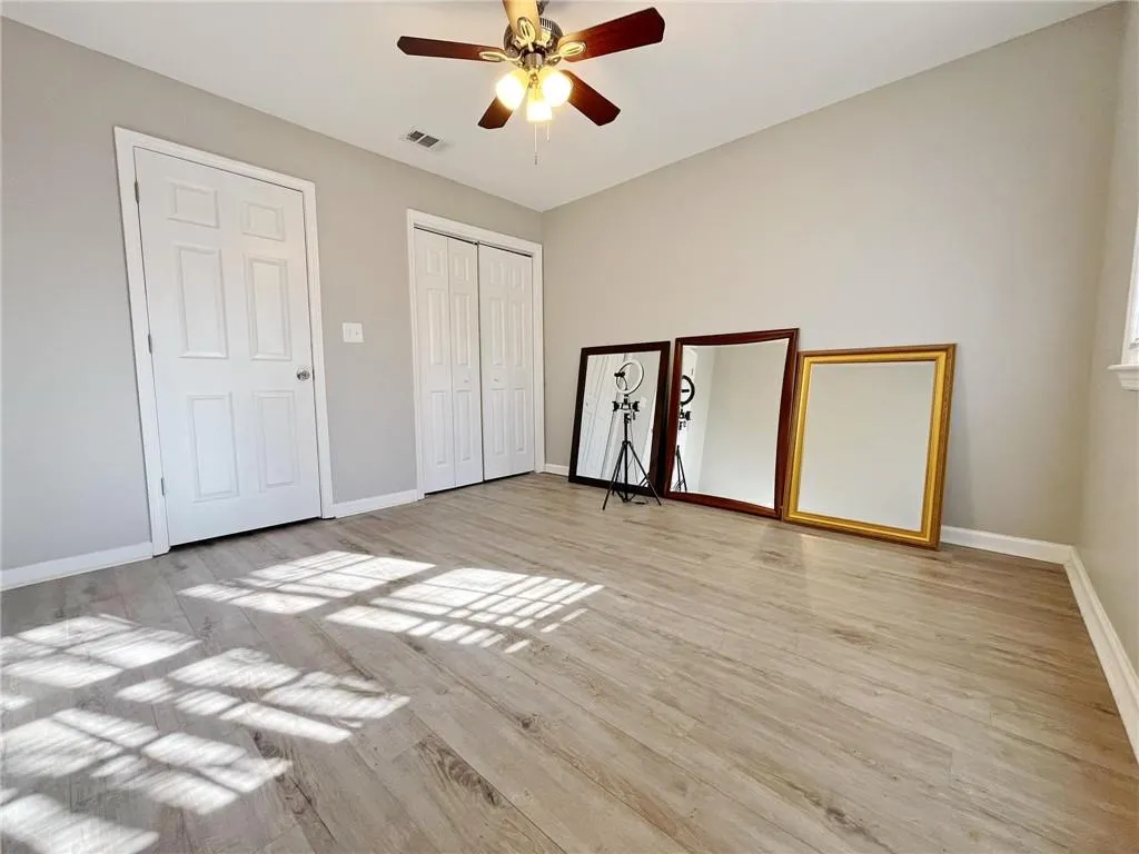 Unfurnished bedroom featuring a ceiling fan, light wood-type flooring, and a closet