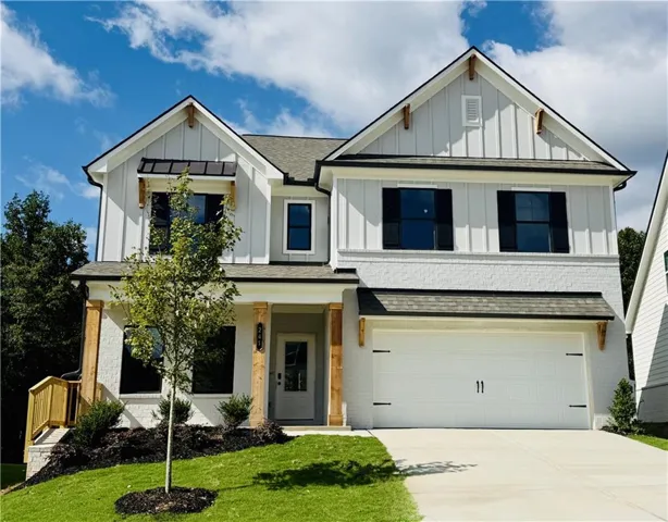 Two-story residence featuring white brick and board-and-batten siding