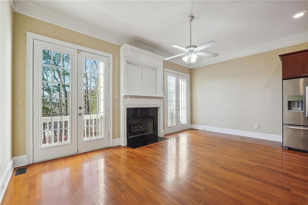 Unfurnished living room with french doors, light hardwood / wood-style flooring, ceiling fan, and a wealth of natural light