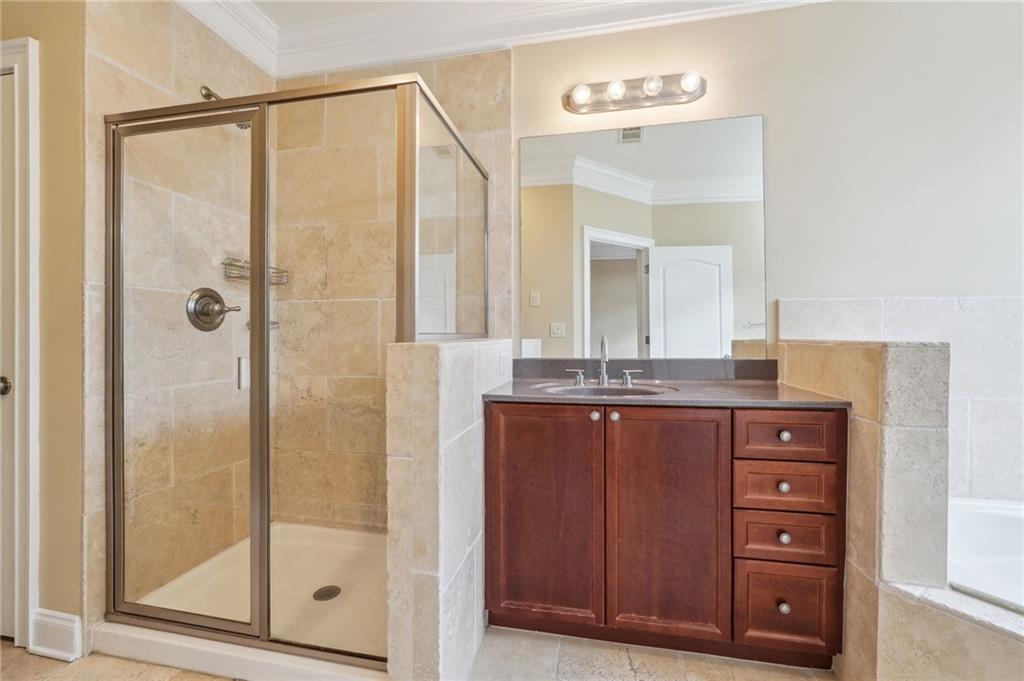 Bathroom with vanity, crown molding, tile walls, separate shower and tub, and tile floors