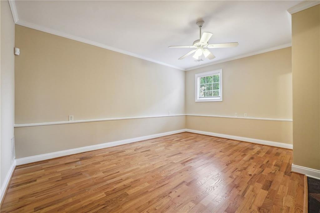 Spare room with light hardwood / wood-style flooring, ceiling fan, and ornamental molding