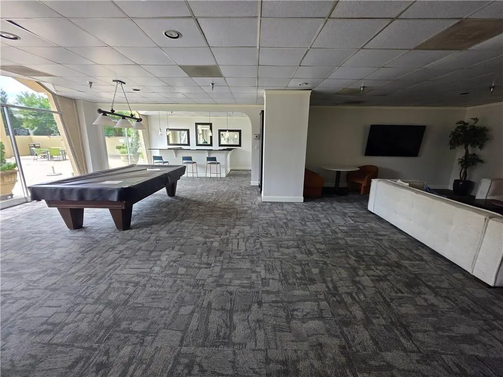 Game room with dark colored carpet, a paneled ceiling, and billiards