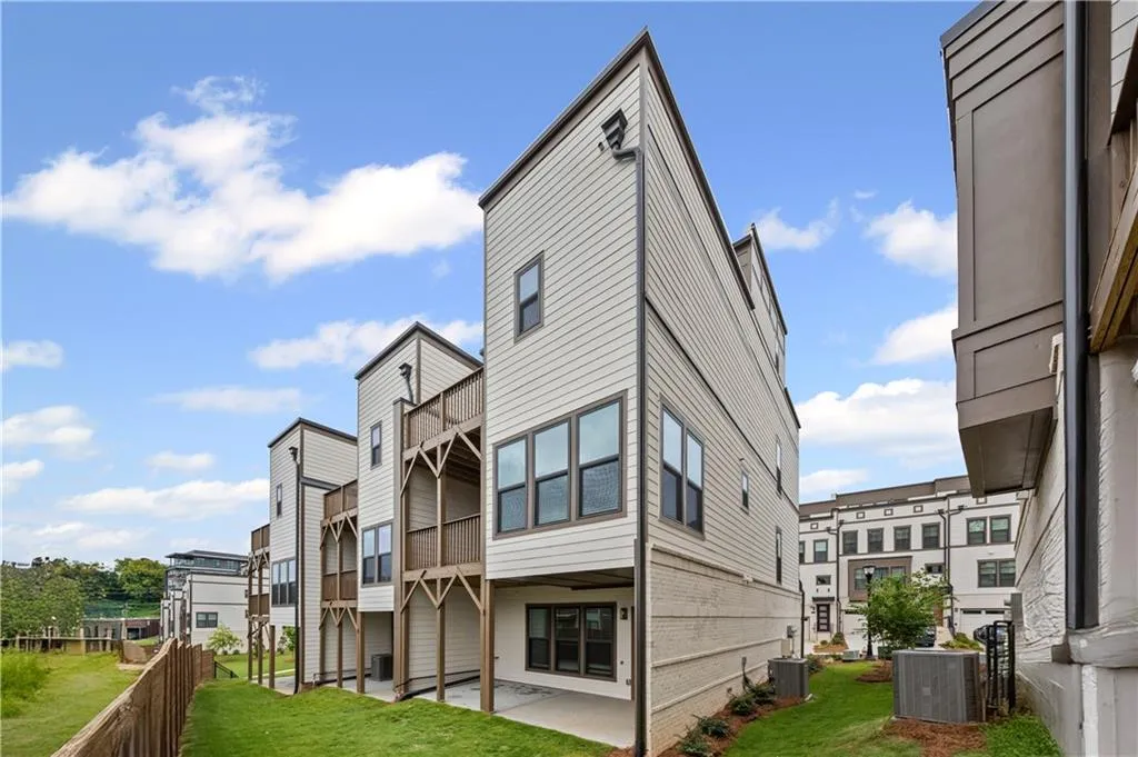 Back of property featuring a patio, main level deck, primary bedroom deck, and sky terrace.