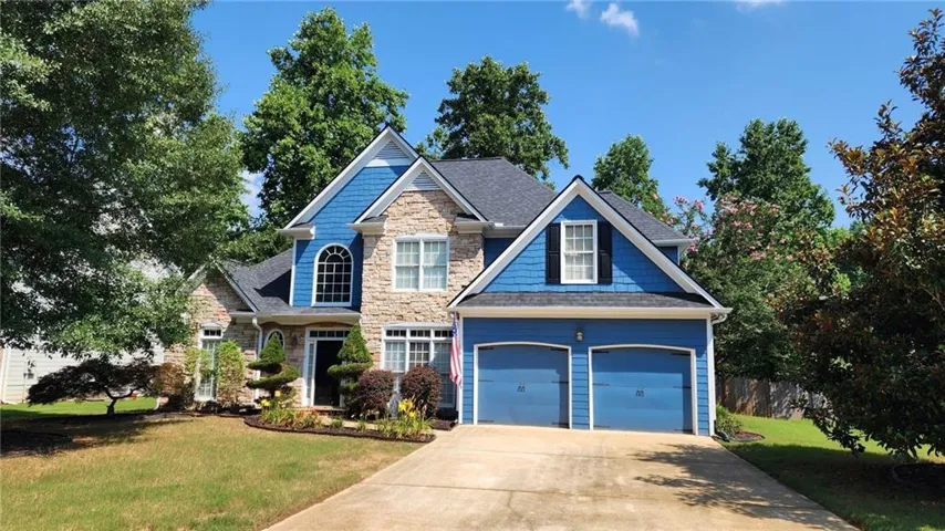 Stone and siding exterior with a dark shingle roof