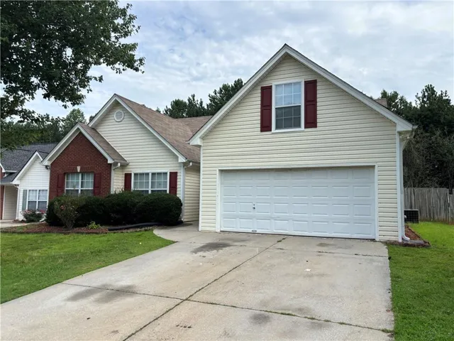 Cream siding exterior with brick accents and dark red shutters