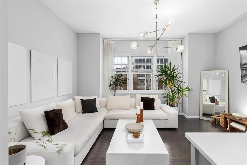 Living room with dark wood-type flooring and baseboards