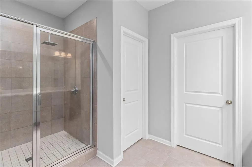 Full bathroom with a shower stall and light tile patterned flooring
