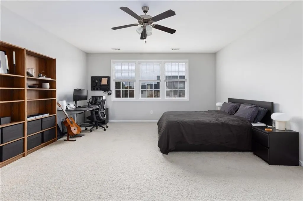 Bedroom with carpet floors, a desk, and a ceiling fan