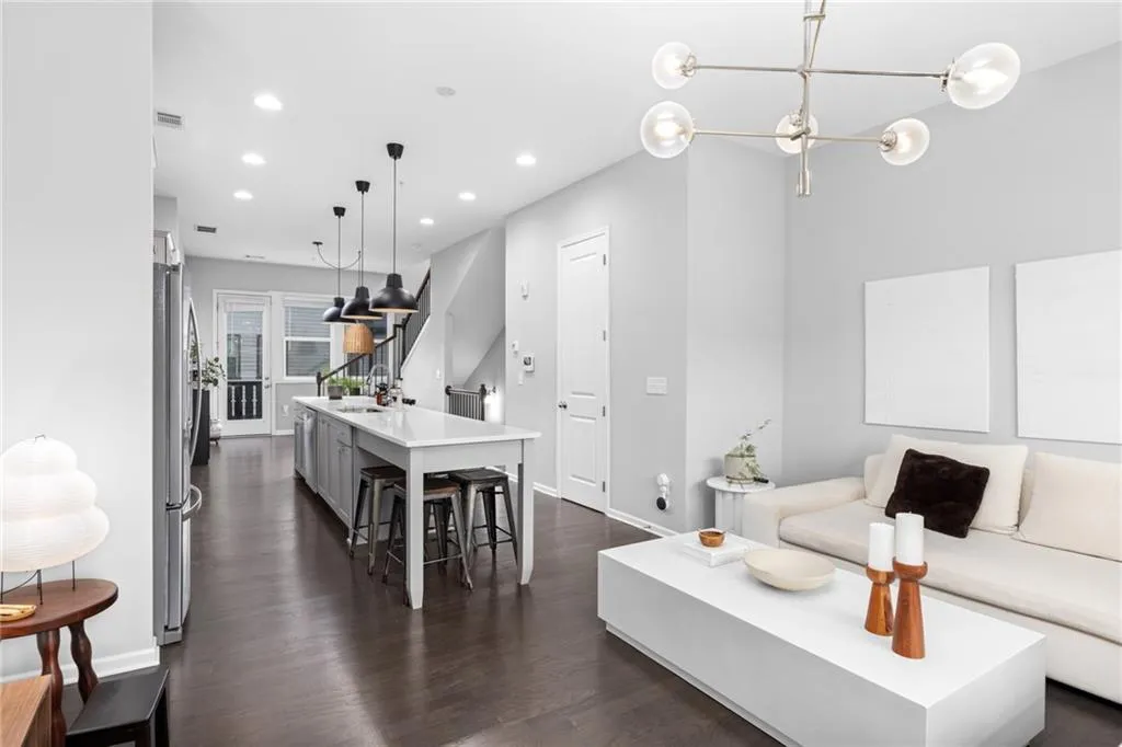Living room featuring dark wood-style floors, recessed lighting, and stairs