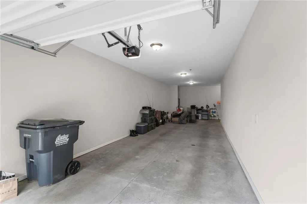 Garage with baseboards and a garage door opener