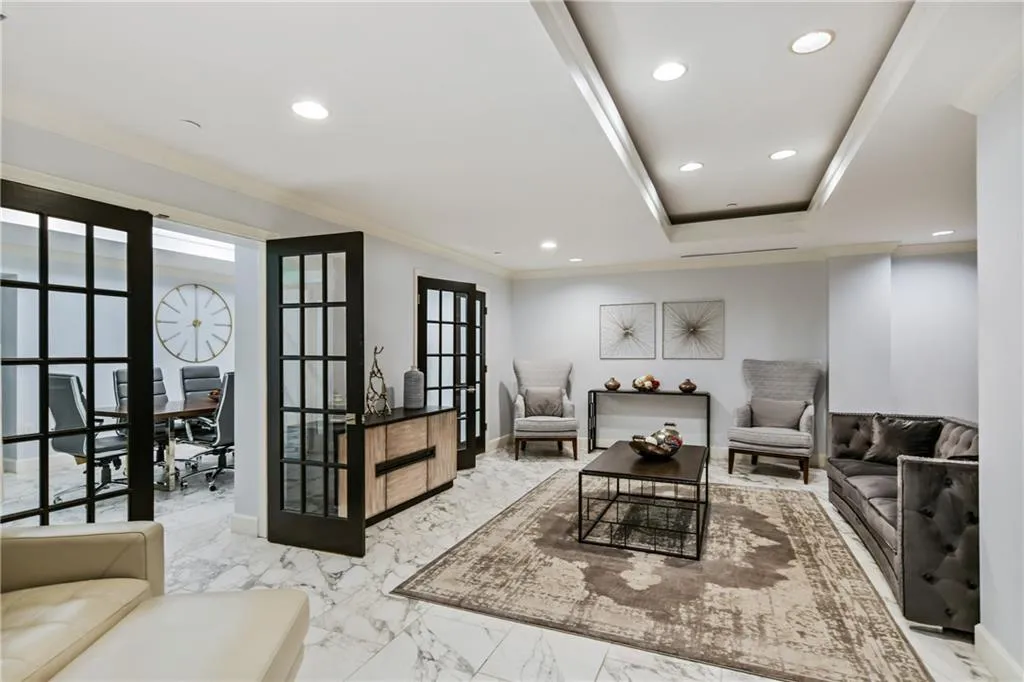 Living area with marble finish floor, french doors, recessed lighting, and crown molding