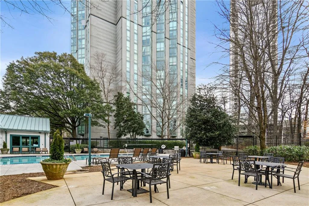 View of patio featuring a community pool and fence