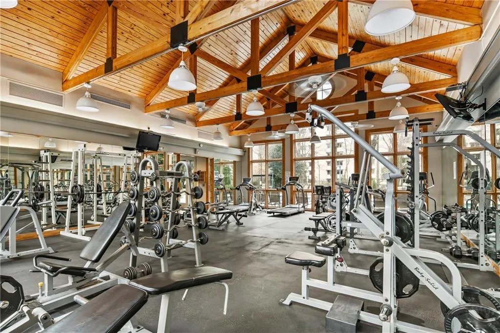 Exercise room with lofted ceiling, visible vents, and wood ceiling