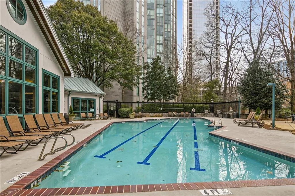 Community pool with fence and a patio area