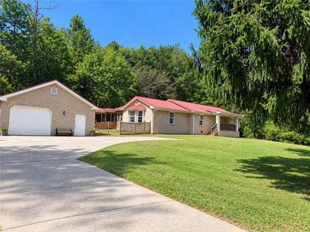 26 Farmer Road NW offers a large front yard with beautiful mature trees, a flat driveway, and plenty of space for parking, creating a welcoming setting with room to enjoy the outdoors.