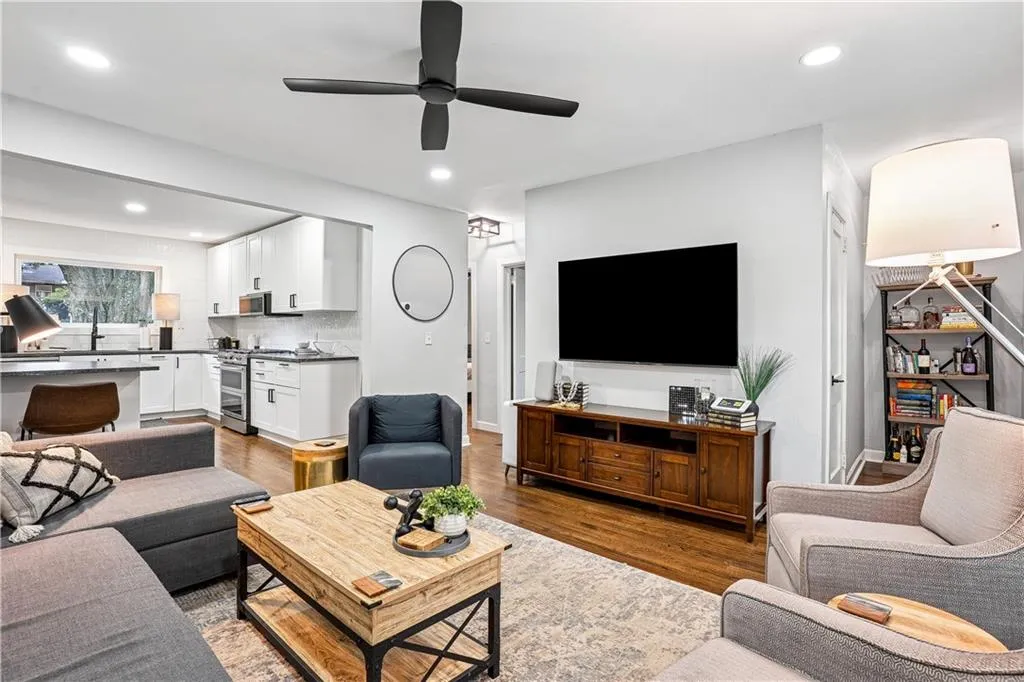Living room with dark wood-style flooring, a ceiling fan, and recessed lighting