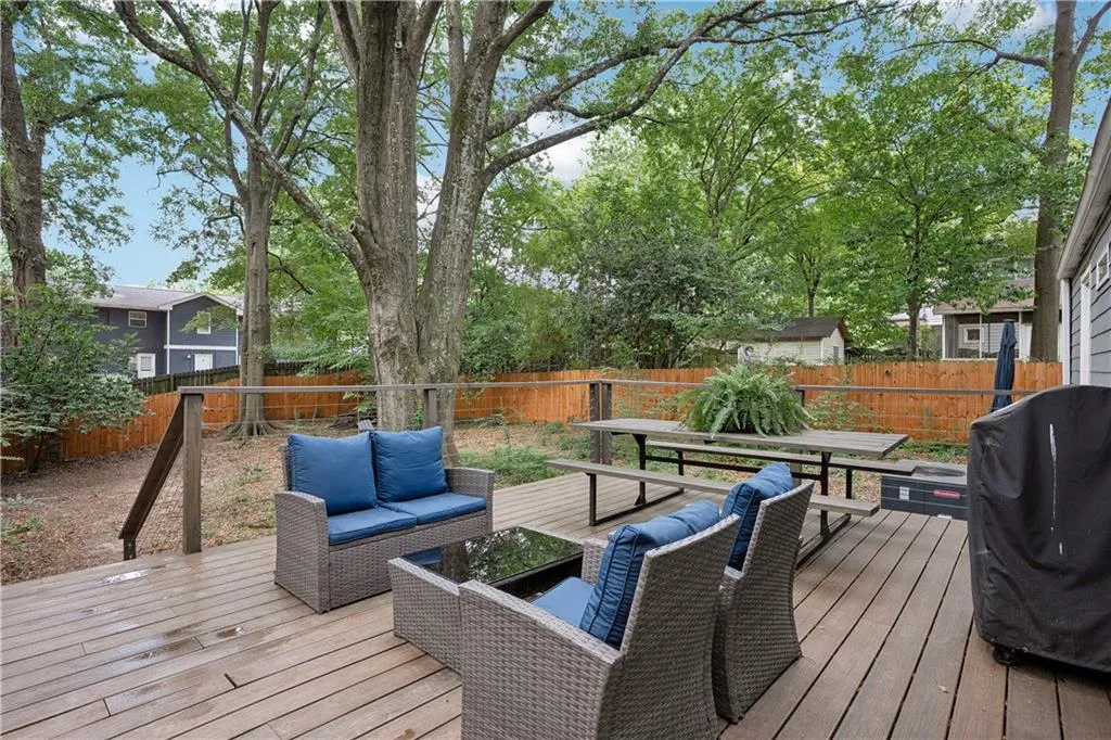 Deck featuring a grill, a fenced backyard, and an outdoor hangout area