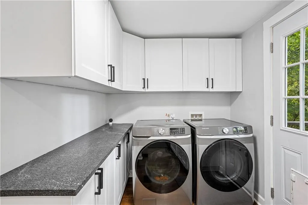 Laundry area with cabinet space, dark wood-type flooring, and washer and dryer