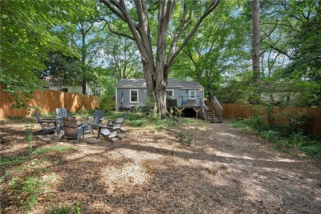 Fenced backyard with an outdoor fire pit, stairs, a deck, and a patio area