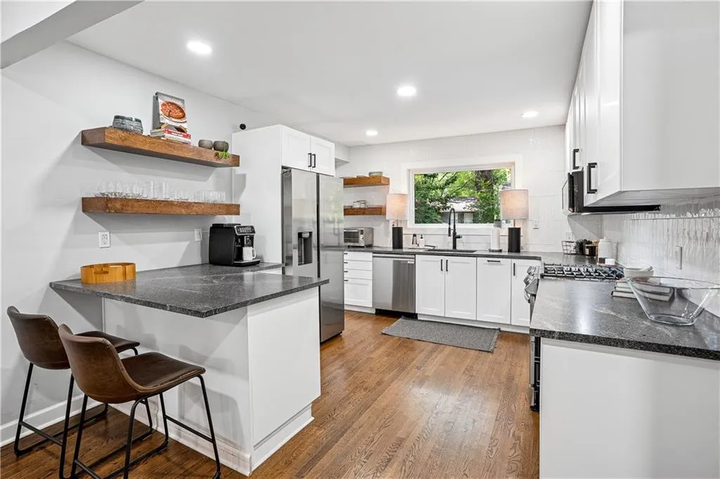 Kitchen featuring open shelves, white cabinetry, stainless steel appliances, dark wood finished floors, and tasteful backsplash