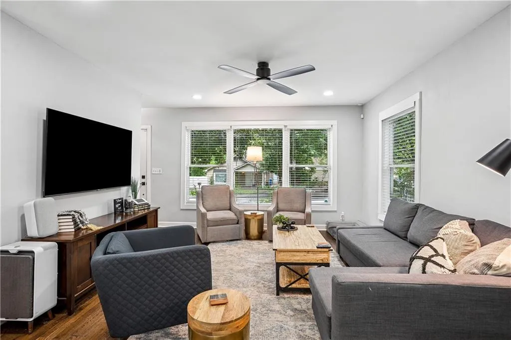 Living area with healthy amount of natural light, wood finished floors, recessed lighting, and a ceiling fan