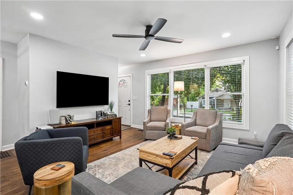 Living area featuring wood finished floors, a ceiling fan, and recessed lighting