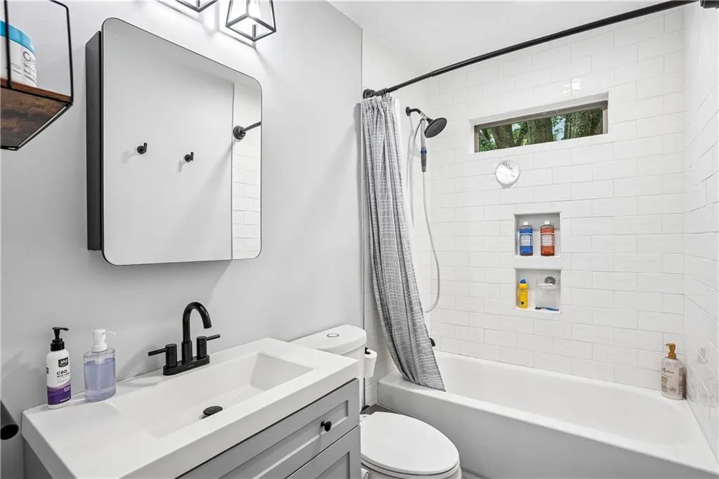Full bath featuring shower / bath combination with curtain and vanity