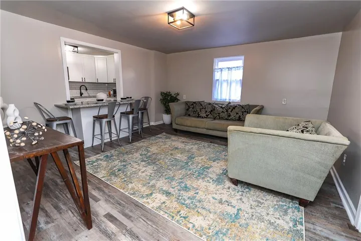 Living room with dark hardwood / wood-style flooring and sink