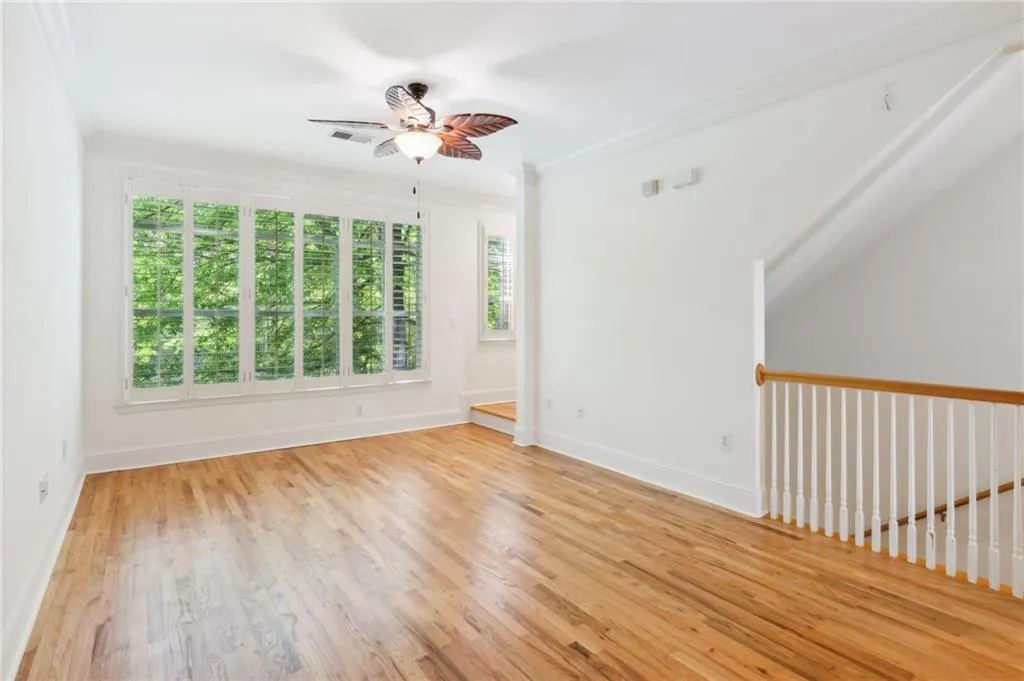 Spare room featuring light hardwood / wood-style flooring, crown molding, and ceiling fan